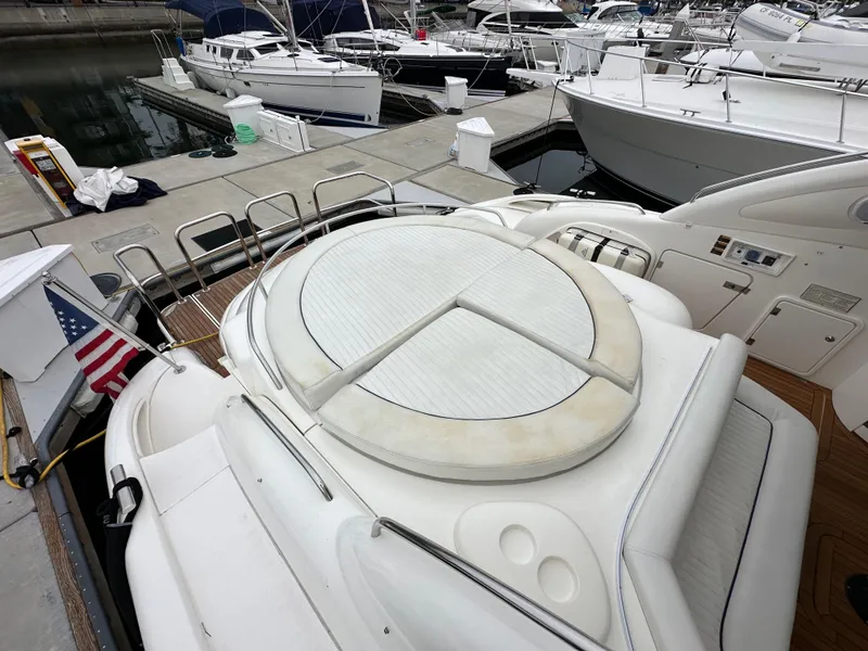 Slide: The Image of Sunseeker Predator 60 yacht, 2000 model, docked with visible sunbathing area and American flag. - 28
