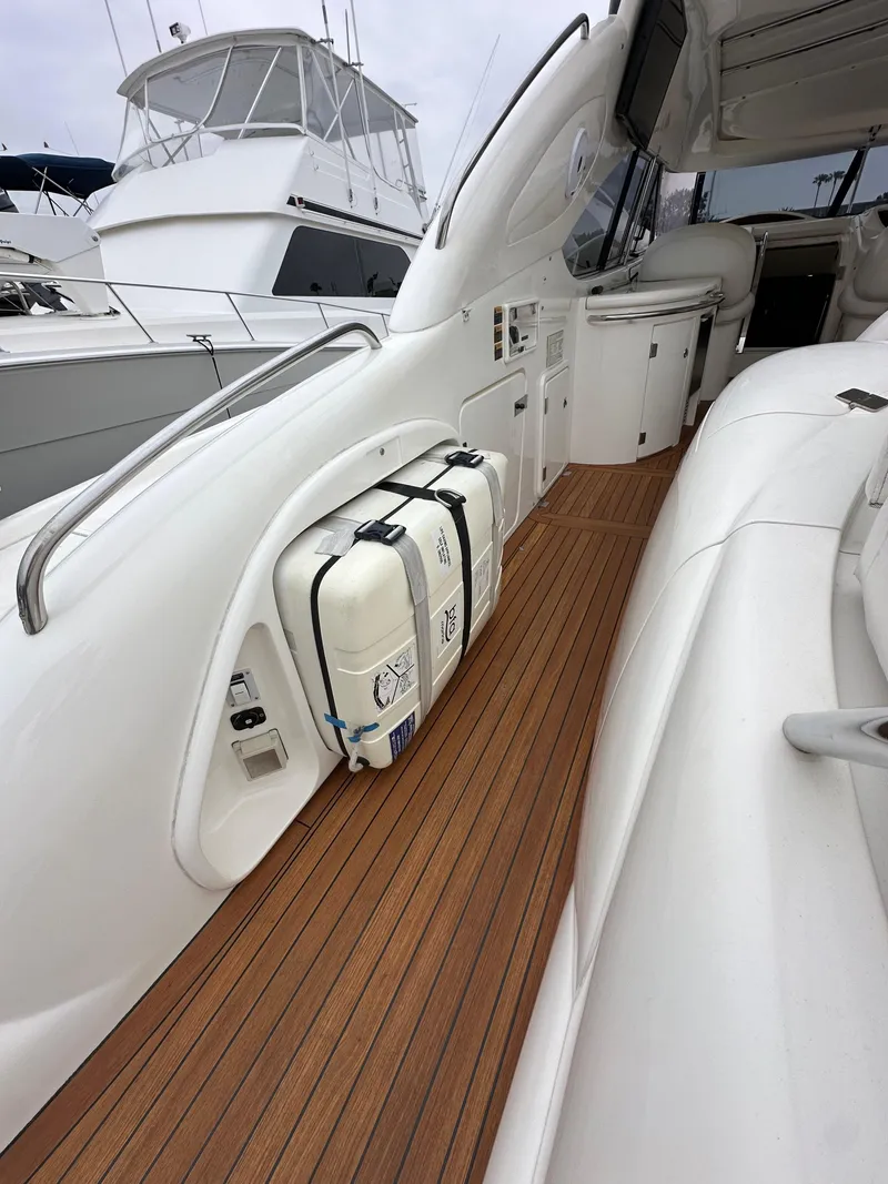 Slide: The Image of Sunseeker Predator 60 yacht deck, 2000 model, featuring sleek white design and wooden flooring. - 29