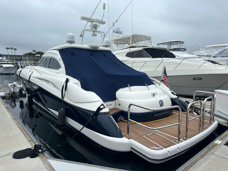 Slide: The Image of Sunseeker Predator 60 yacht, 2000 model, docked at marina with blue cover. - 4