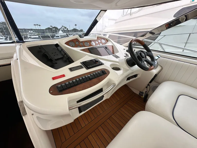 Slide: The Image of Helm of 2000 Sunseeker Predator 60 yacht with modern controls and wooden accents. - 40