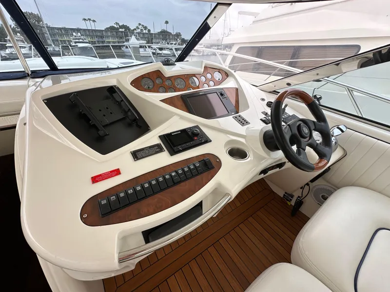 Slide: The Image of Helm of 2000 Sunseeker Predator 60 yacht with modern controls and wooden accents. - 42