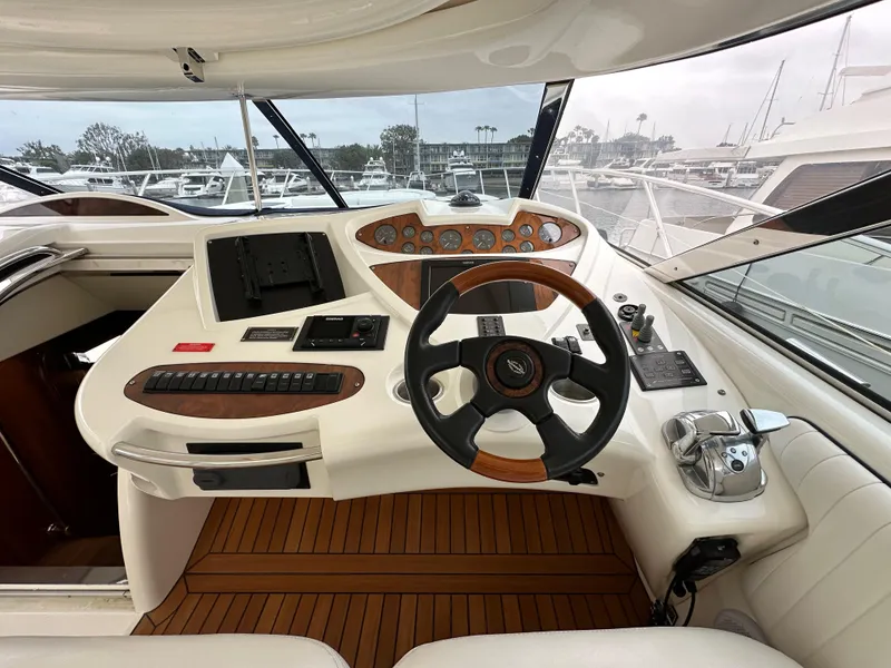 Slide: The Image of Helm of 2000 Sunseeker Predator 60 yacht with steering wheel and navigation controls. - 43