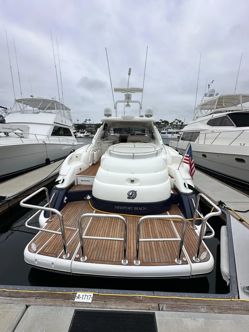 Slide: The Image of Sunseeker Predator 60 yacht, 2000 model, docked with American flag, wooden deck visible. - 6