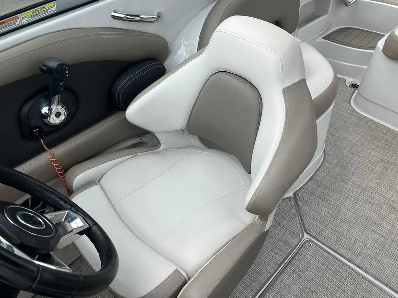 Slide: The Image of 2023 Crownline Eclipse E235 boat interior with steering wheel and comfortable seating. - 11