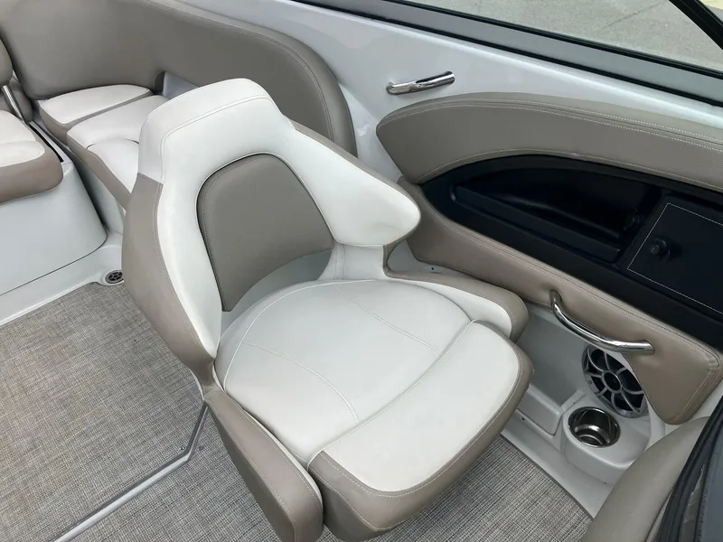 Slide: The Image of 2023 Crownline Eclipse E235 boat interior with beige and white seating, modern design. - 12