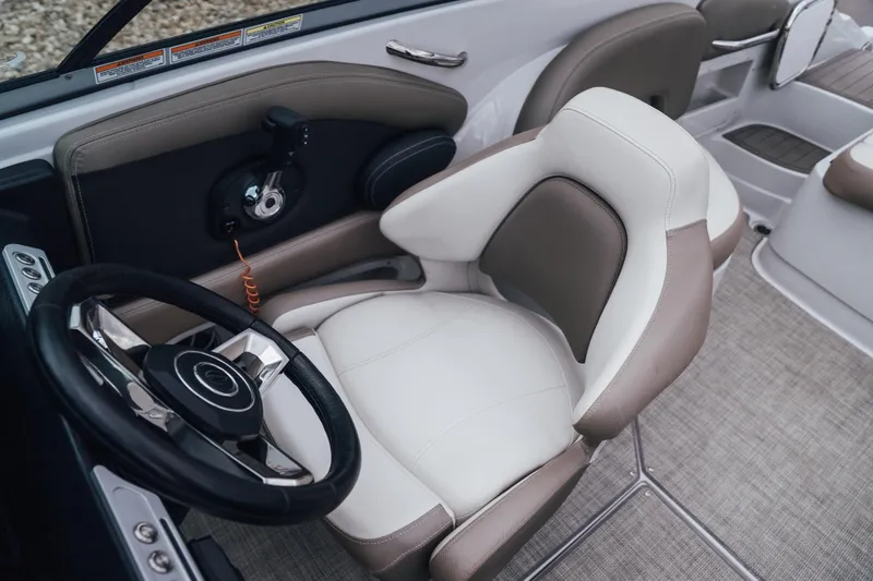 Slide: The Image of 2023 Crownline Eclipse E235 boat interior with steering wheel and plush seating. - 29