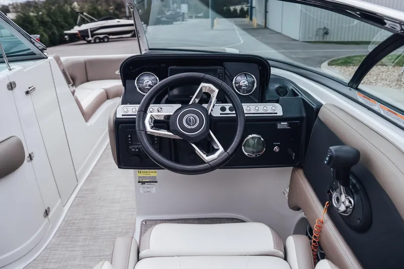Slide: The Image of 2023 Crownline Eclipse E235 boat cockpit with steering wheel and dashboard controls. - 42