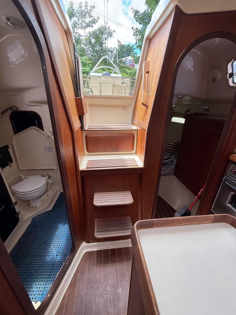 Slide: The Image of Interior of a 1995 Hunter 336 sailboat, featuring wooden steps and compact cabin spaces. - 5