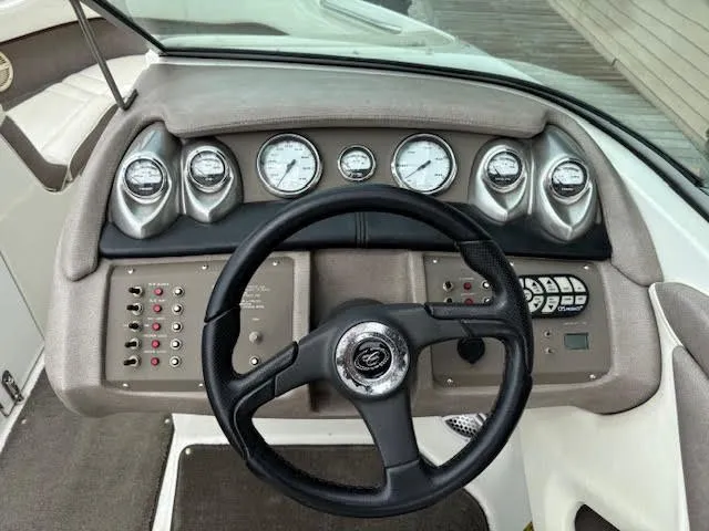Slide: The Image of Steering wheel and dashboard of a 2005 Cobalt 200 boat, featuring gauges and controls. - 14