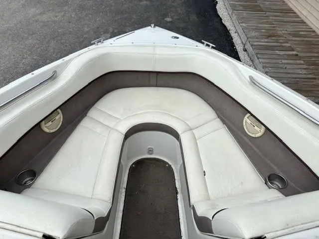 Slide: The Image of 2005 Cobalt 200 boat interior with white and gray seating, cup holders, and speakers. - 15