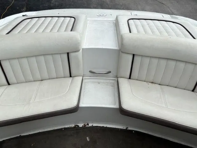 Slide: The Image of White seating area on a 2005 Cobalt 200 boat, featuring cushioned benches. - 19