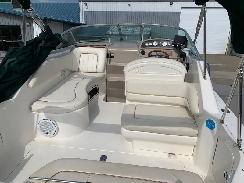 Slide: The Image of 2000 Sea Ray 270 Sundancer boat interior with white seating and dashboard controls. - 2