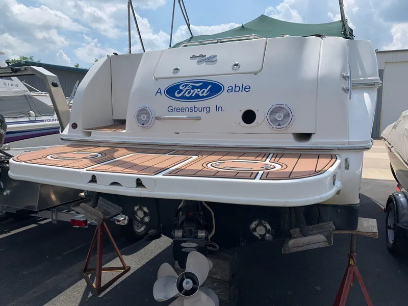 Slide: The Image of 2000 Sea Ray 270 Sundancer boat with custom deck and branding, docked outdoors. - 20