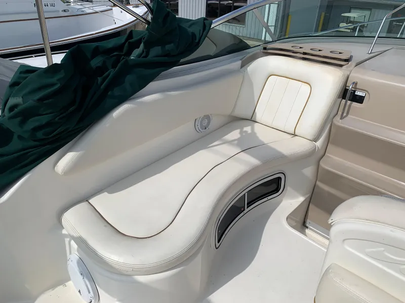 Slide: The Image of 2000 Sea Ray 270 Sundancer boat interior with white seating and green cover. - 5