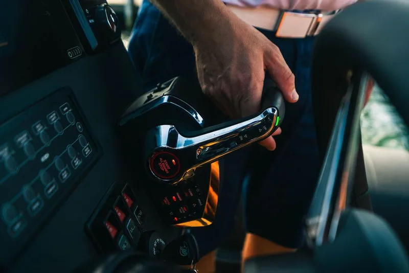 Slide: The Image of Hand operating controls on a 2025 Onda Magna boat dashboard. - 12