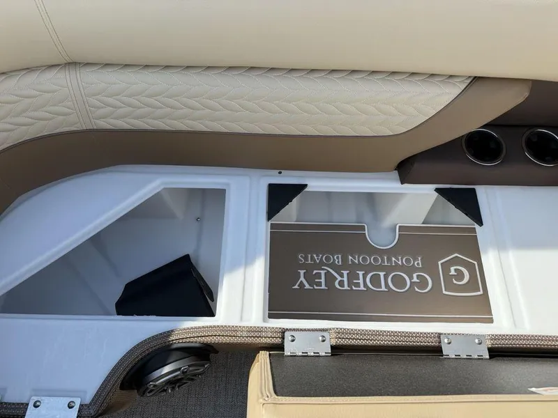 Slide: The Image of 2025 Godfrey Monaco 235 SFL iMPACT boat interior storage compartment with beige upholstery. - 12