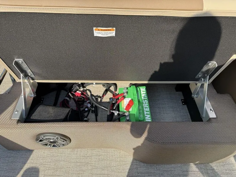 Slide: The Image of Open storage compartment in 2025 Godfrey Monaco 235 SFL boat, revealing battery and wiring. - 18