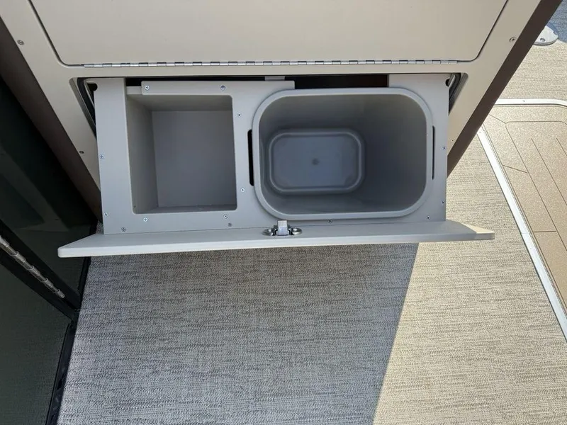 Slide: The Image of 2025 Godfrey Monaco 235 SFL storage compartment with integrated trash bin on boat deck. - 21