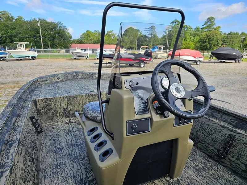 Slide: The Image of 2026 Tracker Grizzly 1860 CC boat interior with steering wheel and camouflage design. - 10