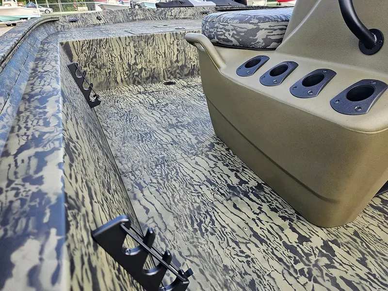 Slide: The Image of 2026 Tracker Grizzly 1860 CC boat interior with camouflage design and rod holders. - 11
