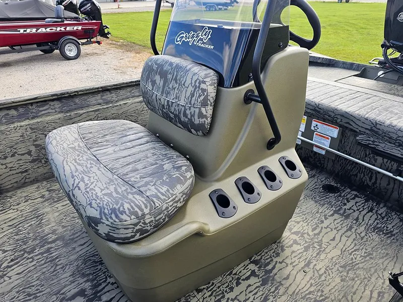 Slide: The Image of 2026 Tracker Grizzly 1860 CC boat interior with camo seating and rod holders. - 12