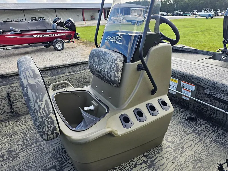 Slide: The Image of 2026 Tracker Grizzly 1860 CC boat interior with camo seats and steering console. - 13
