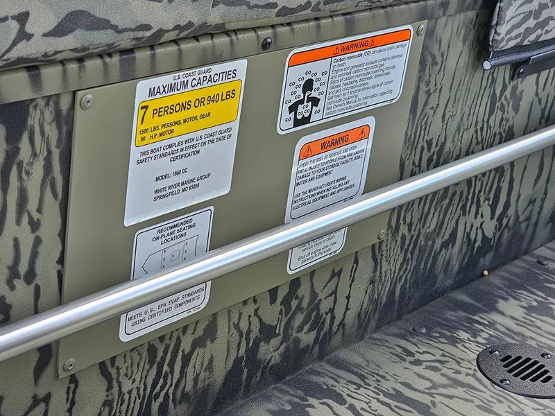 Slide: The Image of 2026 Tracker Grizzly 1860 CC boat capacity and safety warning labels. - 16