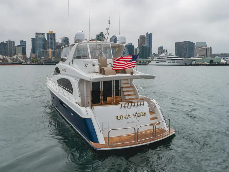 Slide: The Image of 2007 Hatteras 64 Motor Yacht in harbor, city skyline in background. - 2