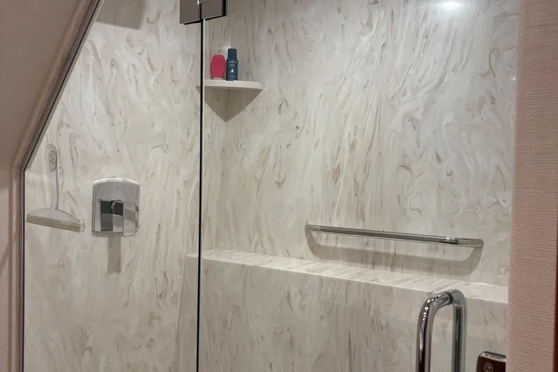 Slide: The Image of Luxurious shower interior on a 2007 Hatteras 64 Motor Yacht, featuring marble walls and modern fixtures. - 22