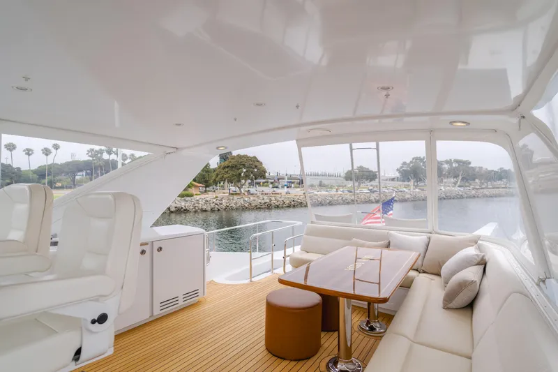 Slide: The Image of Luxurious 2007 Hatteras 64 Motor Yacht interior with elegant seating and scenic waterfront view. - 35