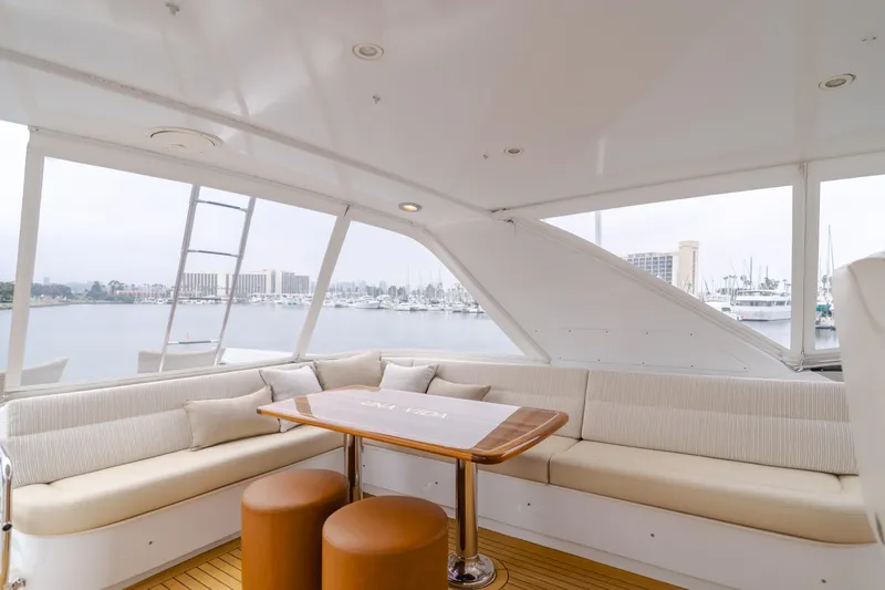 Slide: The Image of Luxurious 2007 Hatteras 64 Motor Yacht interior with elegant seating and scenic marina view. - 36