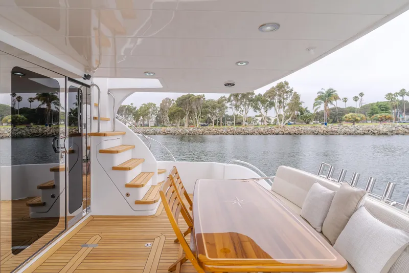 Slide: The Image of 2007 Hatteras 64 Motor Yacht deck with seating, table, and water view. - 38