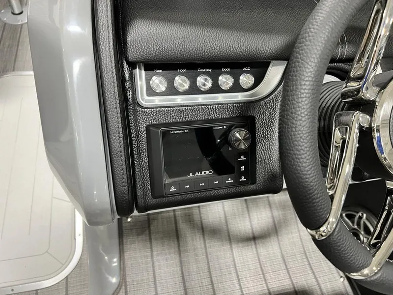 Slide: The Image of 2025 Godfrey AquaPatio 235 SFLC dashboard with JL Audio system and control switches. - 19