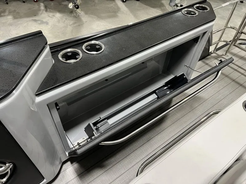 Slide: The Image of Interior of 2025 Godfrey AquaPatio 235 SFLC boat, featuring storage compartment and cup holders. - 21