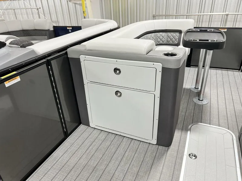 Slide: The Image of 2025 Godfrey AquaPatio 235 SFLC boat interior with seating, storage, and table. - 8