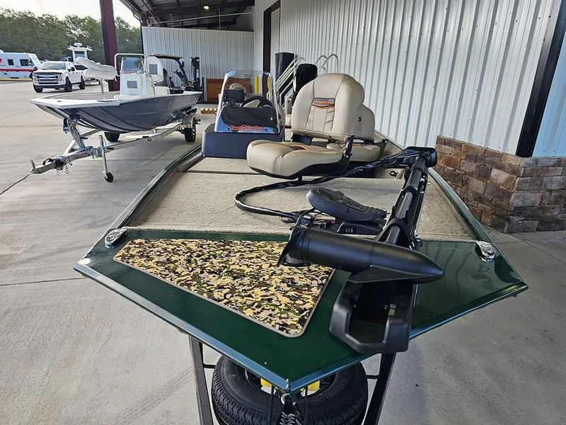 Slide: The Image of 2026 Tracker Bass Tracker Classic Limited boat with seating and trolling motor, parked outdoors. - 4
