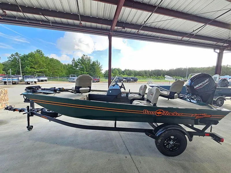 Slide: The Image of 2026 Tracker Bass Tracker Classic Limited boat under a metal roof, parked on a trailer. - 6