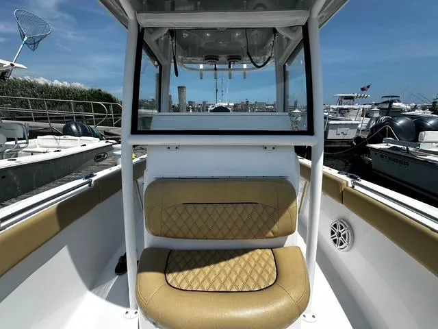 Slide: The Image of 2018 Sportsman Open 252 Center Console boat with tan seating, docked in a marina. - 10