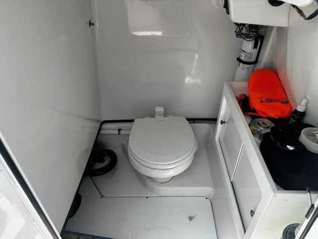 Slide: The Image of 2018 Sportsman Open 252 Center Console boat interior with toilet and storage. - 12