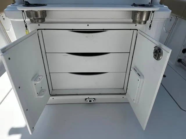 Slide: The Image of 2018 Sportsman Open 252 Center Console storage compartment with open doors and drawers. - 14