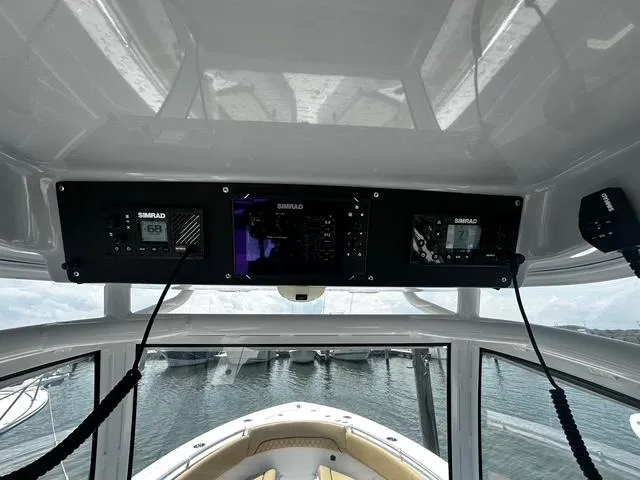 Slide: The Image of 2018 Sportsman Open 252 Center Console boat dashboard with Simrad electronics, docked at marina. - 16