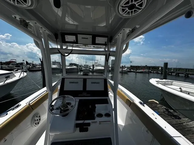 Slide: The Image of 2018 Sportsman Open 252 Center Console boat docked at marina, featuring Simrad electronics. - 23