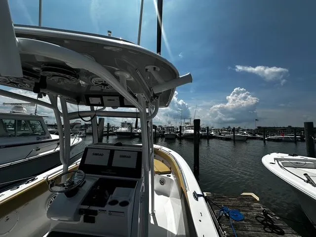 Slide: The Image of 2018 Sportsman Open 252 Center Console boat docked at marina under clear sky. - 25