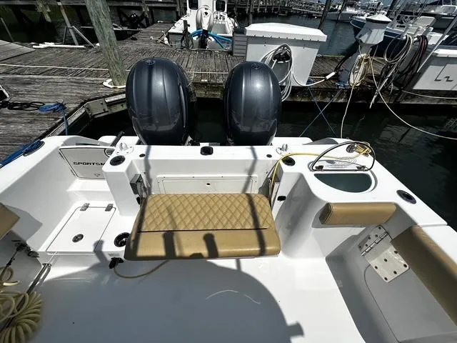 Slide: The Image of 2018 Sportsman Open 252 Center Console boat with twin engines at a marina dock. - 29