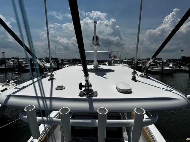 Slide: The Image of 2018 Sportsman Open 252 Center Console boat docked at marina under cloudy sky. - 32