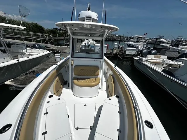 Slide: The Image of 2018 Sportsman Open 252 Center Console boat docked at marina, showcasing spacious deck. - 8