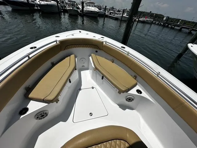 Slide: The Image of 2018 Sportsman Open 252 Center Console boat interior with tan seating, docked at marina. - 9