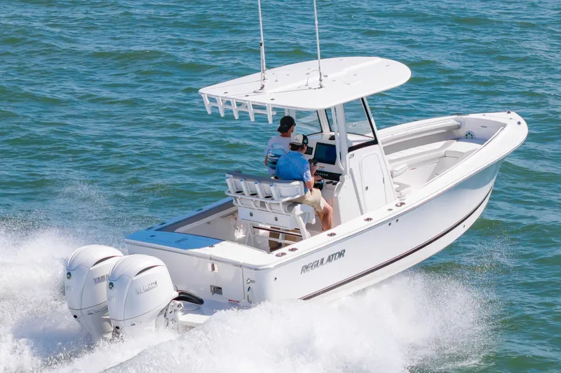 Slide: The Image of 2026 Regulator 23 boat cruising on open water with twin Yamaha engines. - 6