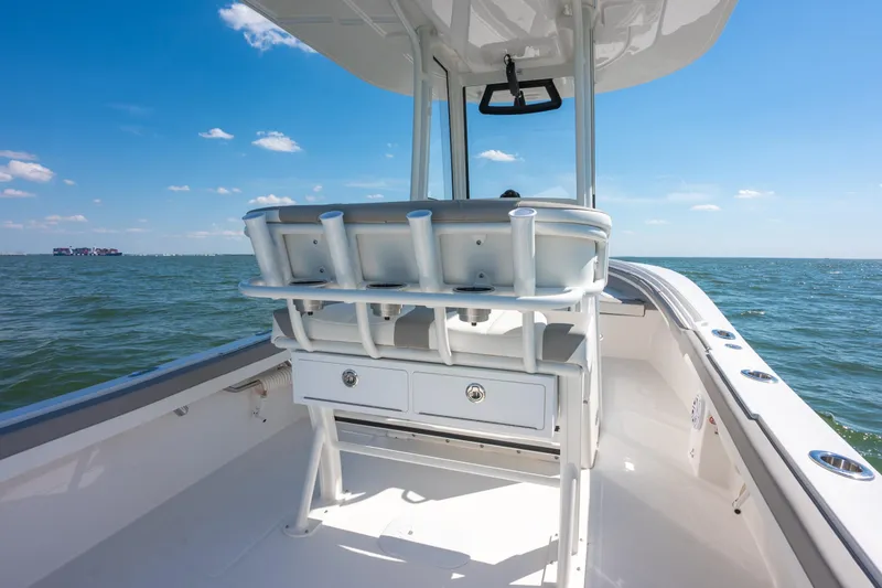 Slide: The Image of 2026 Regulator 23 boat interior with rod holders, ocean view, and clear blue sky. - 9
