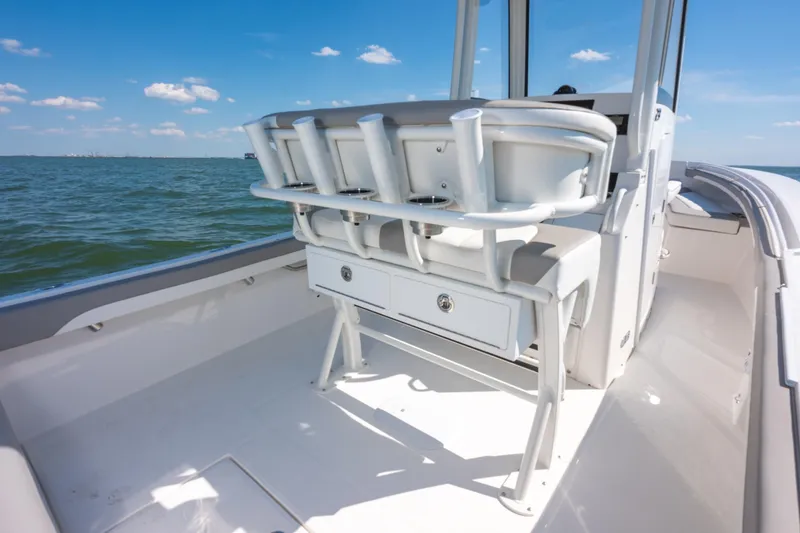 Slide: The Image of 2026 Regulator 23 boat interior with seating and storage, on calm waters under blue sky. - 11
